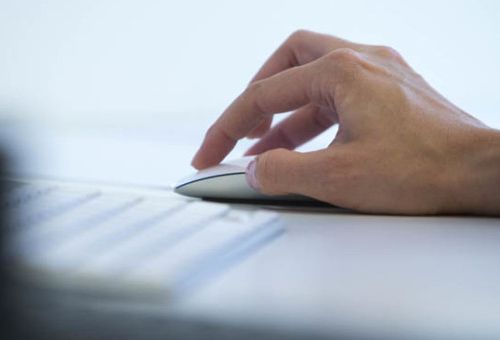 hand som håller i datormus för att skicka filer med WeTransfer eller Sprend